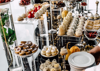 buffet of desserts on a long table at a wedding