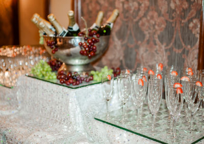 silver barrell with chanpagne and champagne glasses in rows next to the bucket