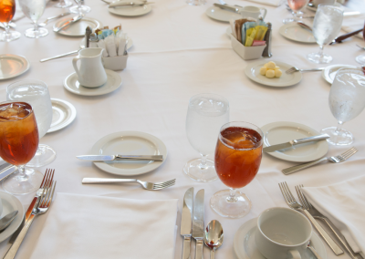 round table with a white tablecloth plates and water glasses filled with juice