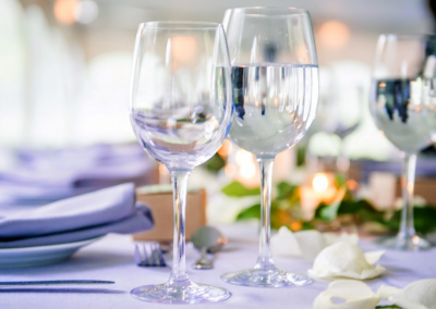 long table lined with glasses and plates in white