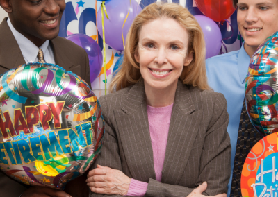 lady sitting withmhappy retirement balloons around her