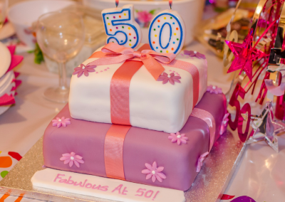 50th birthday cake 3 layers decorated in pinks and purples